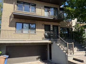 Immeuble de brique beige avec balcons et grandes fenêtres, logements à louer